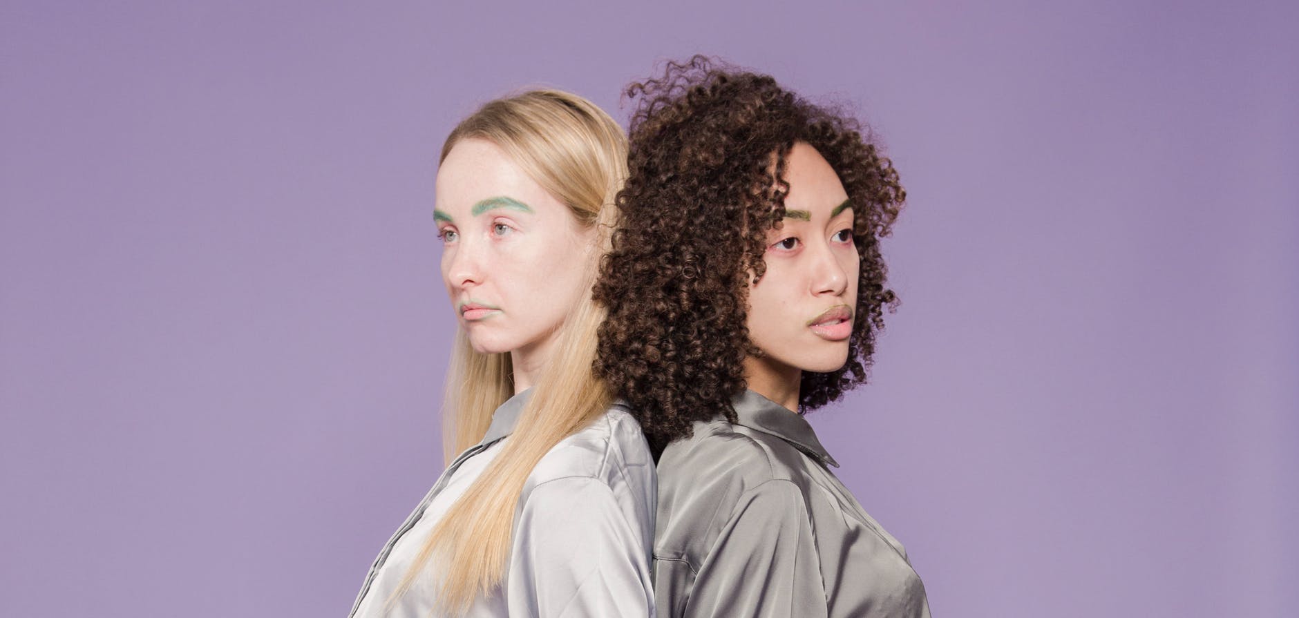 unhappy multiethnic women standing back to back in studio